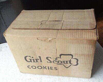 an old cardboard box with the word Girl Scout printed on the side