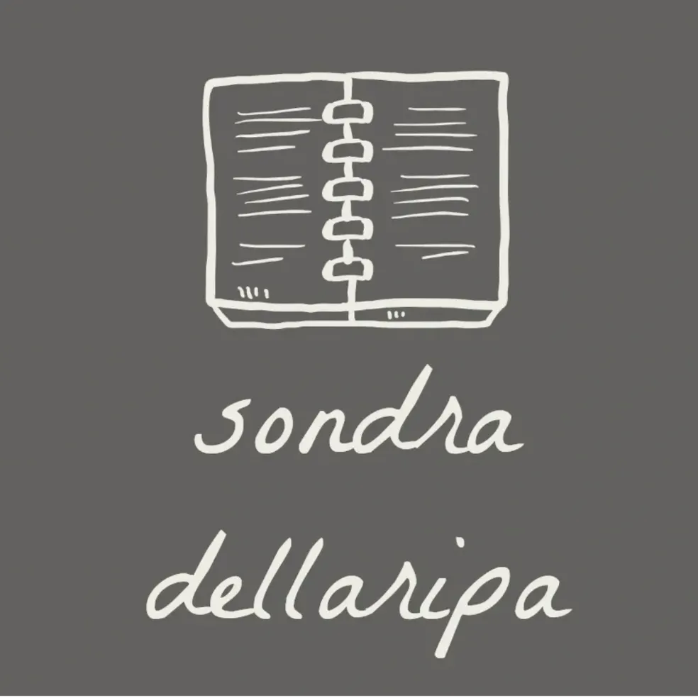 a grey and cream hand drawn iage of an open book with the name sondra dellaripa scripted below it