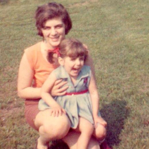 a woman kneeling with a young girl on her knee.